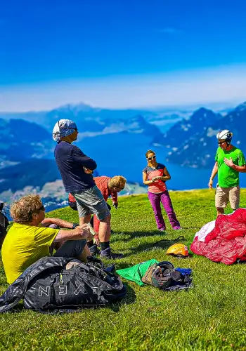 Fluglehrer gibt ein Briefing am Startplatz, bei dem Meteo, Manöver und der Tagesablauf besprochen werden.
