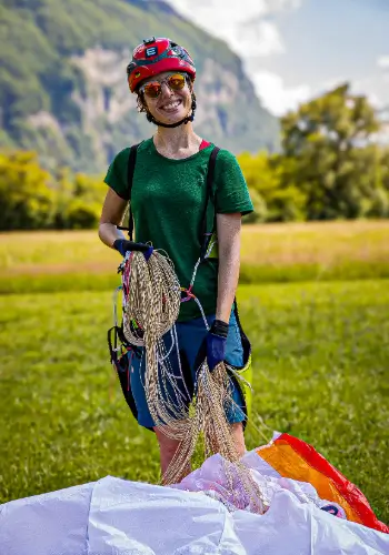 Pilotin strahlt nach einem erfolgreichen Gleitschirmflug während der Ausbildung bei der Flugschule touch and go Paragliding.