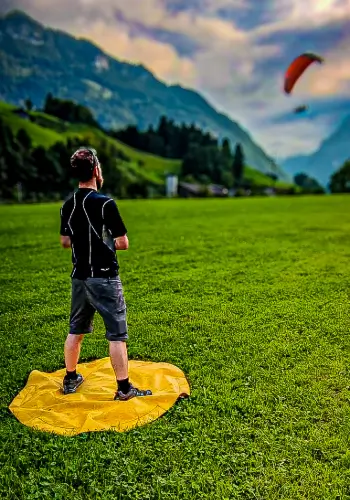 Fluglehrer überwacht die Landung eines Schülers während des individuellen Coachings bei touch and go Paragliding.