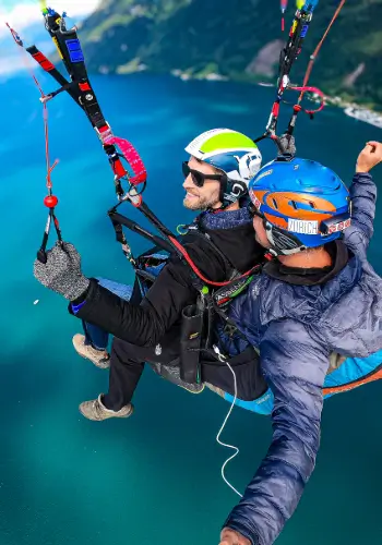Passagier übernimmt das Steuer während eines Tandemflugs über dem Vierwaldstädtersee mit touch and go Paragliding.