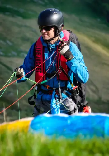 Pilot sortiert sorgfältig die Leinen seines Gleitschirms vor dem Start während des Sicherheitstrainings von touch and go Paragliding.