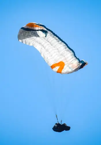 Pilot führt während des Sicherheitstrainings der Gleitschirmflugschule touch and go einen Fullstall über dem Wasser durch.