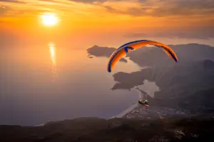 Gleitschirmflug während des Sonnenuntergangs über Ölüdeniz mit touch and go Paragliding.