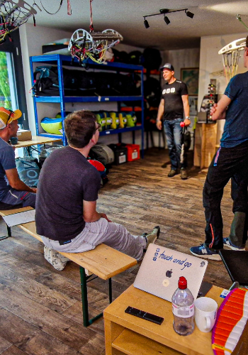 Teilnehmer des Sicherheitstraining üben und besprechen Manöver am Simulator während des Simulationstags bei touch and go Paragliding in der Zentralschweiz.