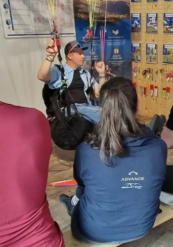 Der Fluglehrer zeigt. beim Manöverbriefing im Simulator während der Ausbildung bei touch and go Paragliding die Manöver vor.