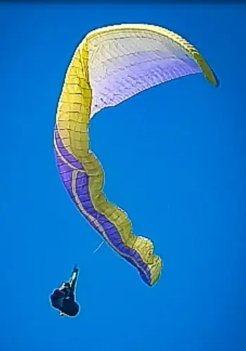Pilotin simuliert einen Seitenklapper während des Sicherheitstrainings am Gardasee von touch and go Paragliding unter Anleitung erfahrener Trainer.