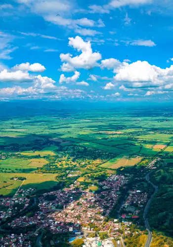 Gleitschirmpiloten fliegen über die malerischen Landschaften des Valle de Cauca in Kolumbien während einer Reise mit touch and go Paragliding.