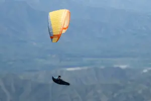 Gleitschirmpilot mit einem Nova Codex fliegt Thermik in Santafe während einer Kolumbienreise mit touch and go Paragliding.