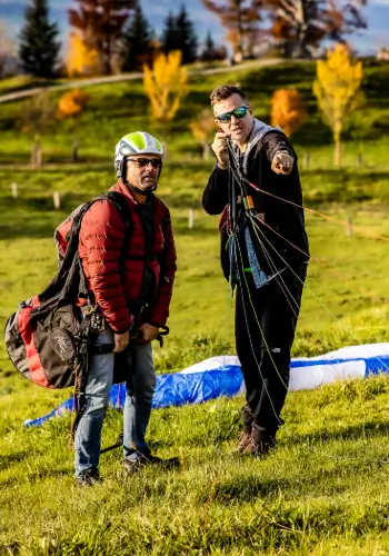 Ein Fluglehrer zeigt einem Flugschüler am Teambuilding-Tag, wie er die Leinen korrekt kontrollieren und handhaben muss – ein wichtiger Schritt in der Startvorbereitung.