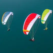 Nova Gleitschirme fliegen hoch über dem Meer.