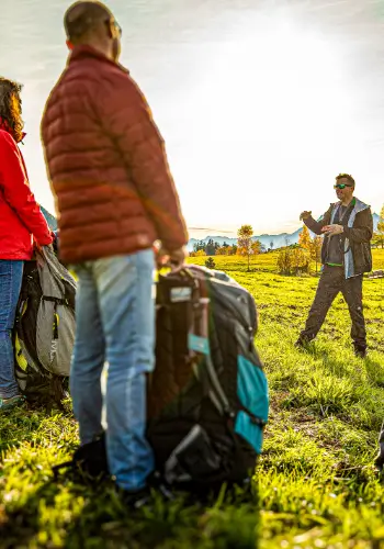 Ein touch and go Fluglehrer hält ein Briefing am Übungshang, um die Schüler in die Grundlagen des Gleitschirmfliegens einzuführen.