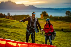 Fluglehrer kontrolliert die Leinen eines Gleitschirms am Übungshang während der Ausbildung bei touch and go Paragliding.