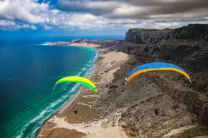 Gleitschirmpiloten soaren an der Küste über dem Meer und nutzt die dynamische Aufwindströmung.