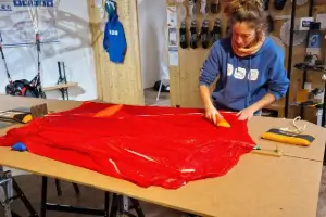 Mitarbeiterin packt einen Notschirm sorgfältig im Shop, um sicherzustellen, dass er für den Einsatz im Notfall bereit ist.